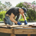 A Handyman worker making patio outside close to a pool